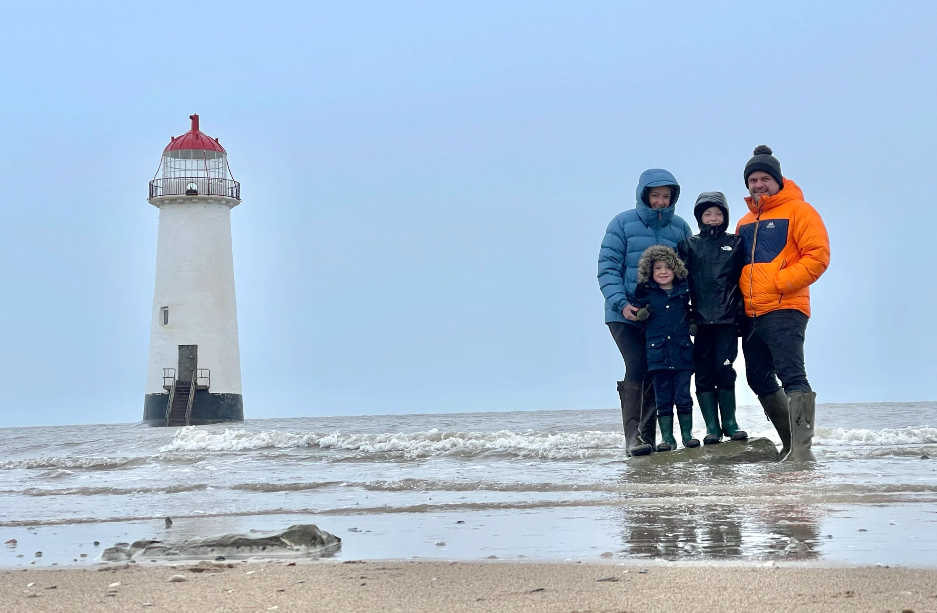 The Rose & Fern family on the beach beside the lighthouse